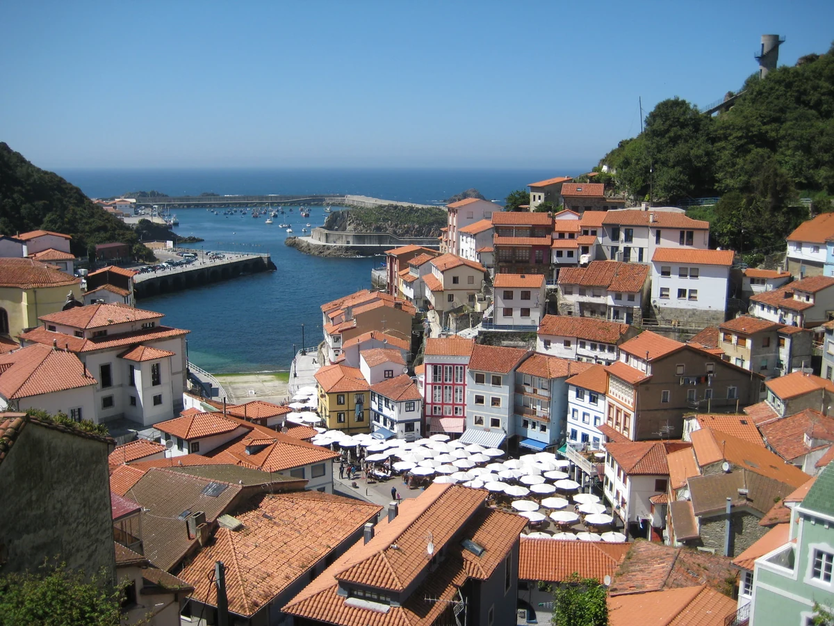 A colourful Spanish coastal village with terracotta roofs and a small harbour